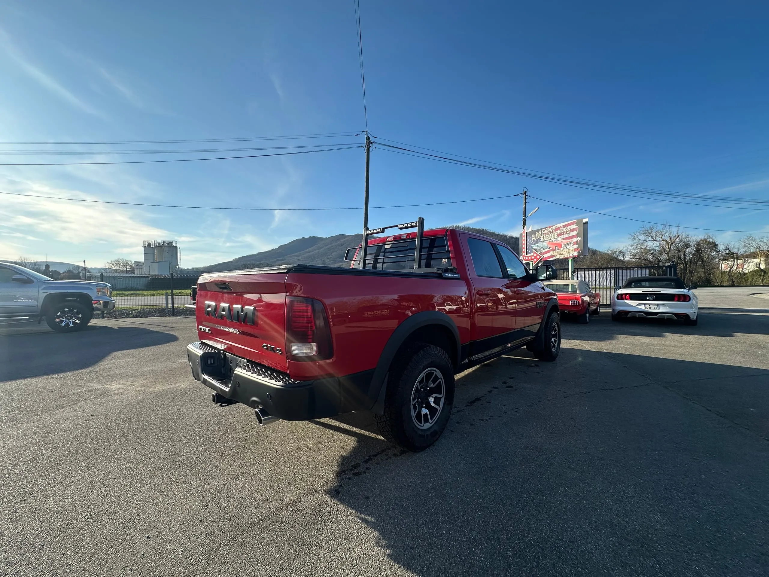 Dodge Ram Rebel rouge vu de trois quarts arrière avec son couvre-benne et son rack