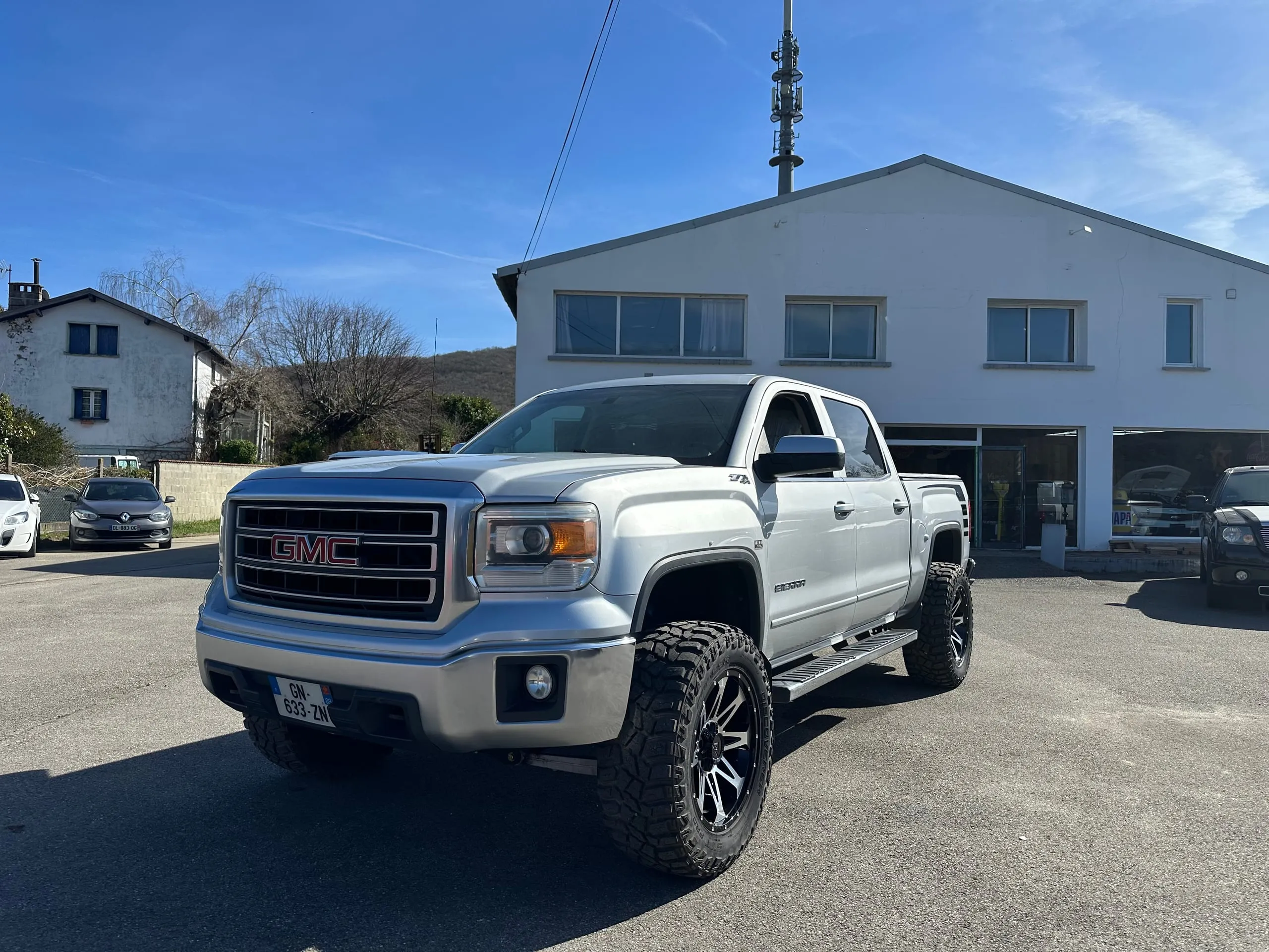 GMC Sierra Denali Crew Cab gris argent vu de trois quarts avant avec ses grandes jantes