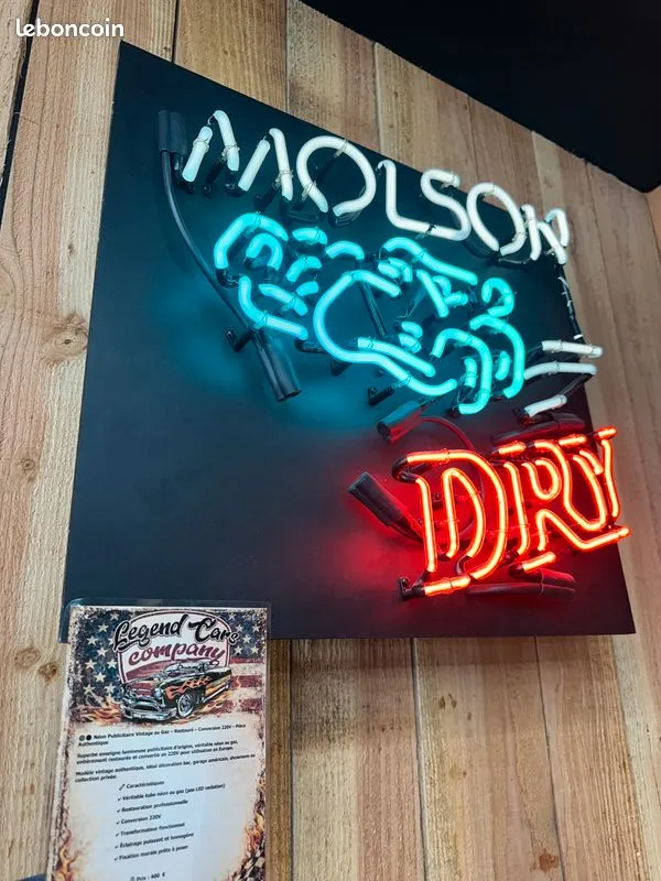 Néon Molson Dry bleu, blanc et rouge allumé sur un panneau noir